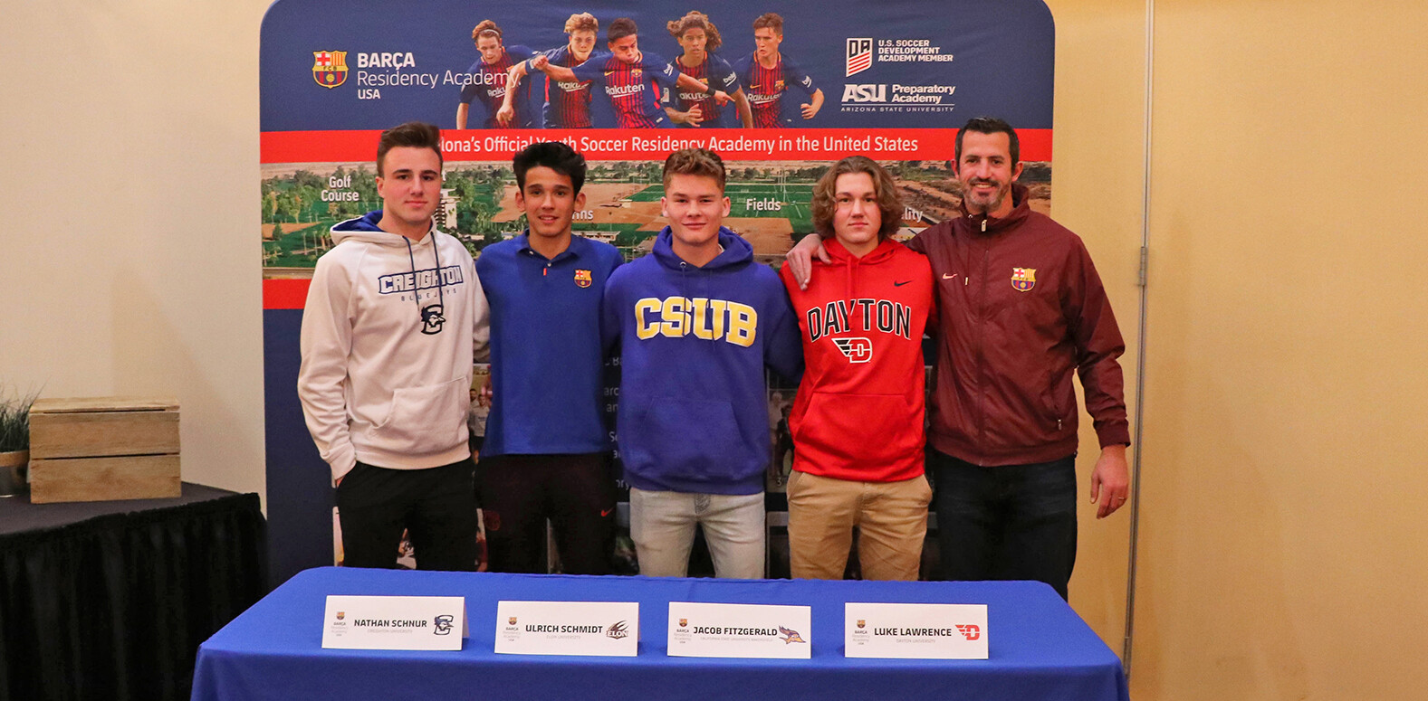 Nathan Schnur, Ulrich Schmidt, Jacob Fitzgerald, Luke Lawrence, and head coach Ged Quinn posing for a picture at the signing day banquet