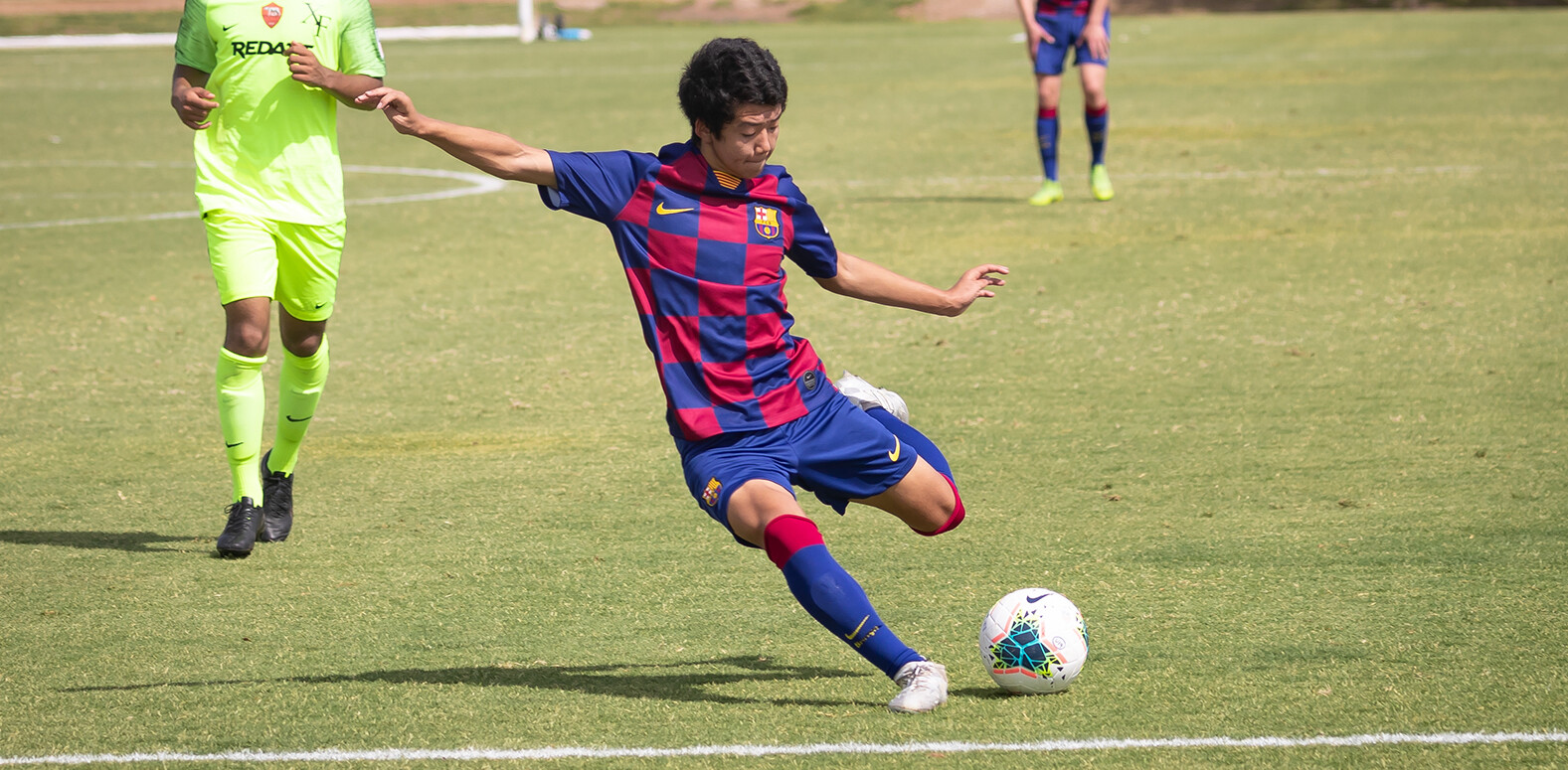 Takumi Ikeda striking the ball down the field