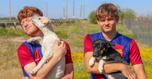 Barca Residency Academy players Connor Bradford and Joel Torbic playing with dogs from Pinal County Animal Care and Control